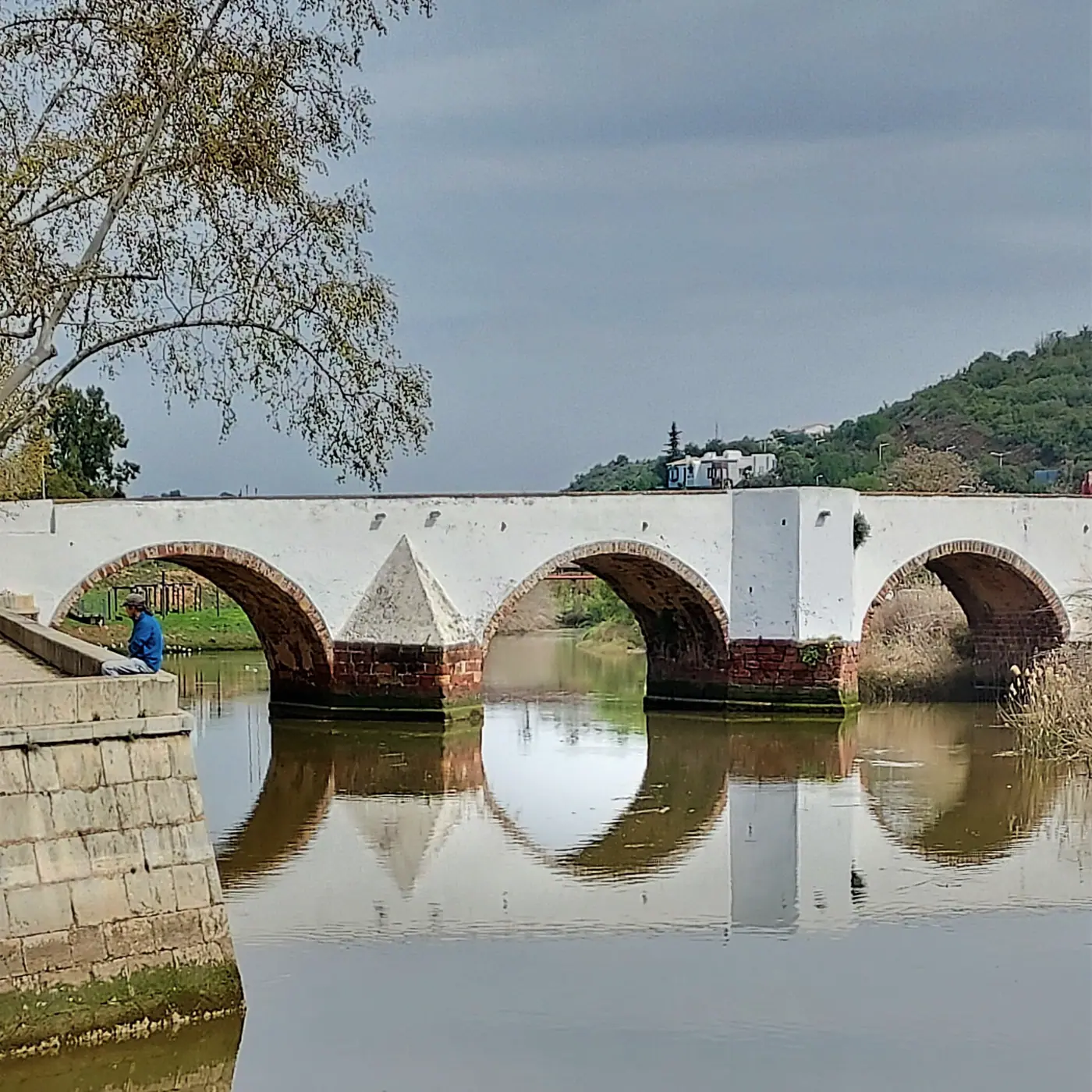 The old Roman bridge of Silves reflected in the still river
